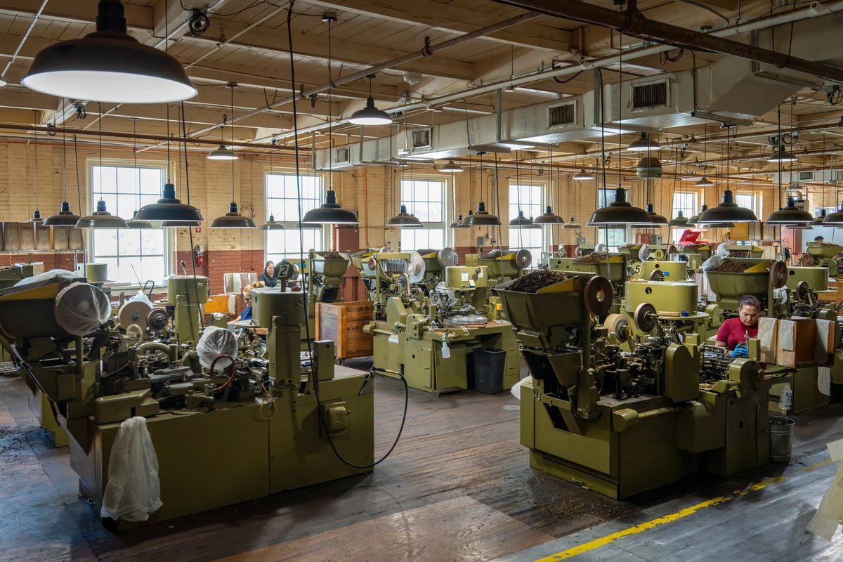 Rows of antique olive-green cigar machines on the factory floor at J.C. Newman&rsquo;s El Reloj in Ybor City