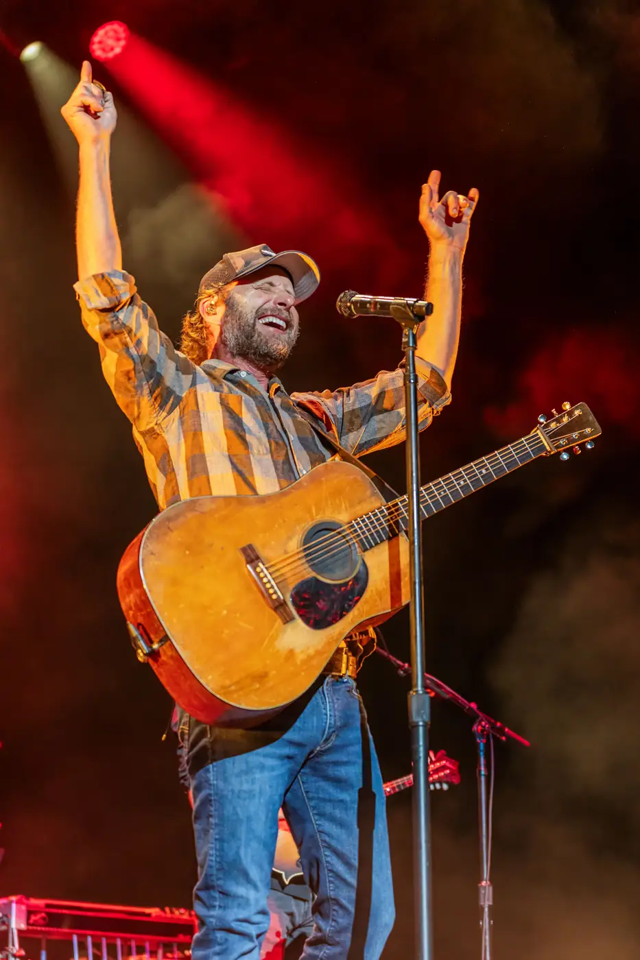 Dierks Bentley with arms raised in red light
