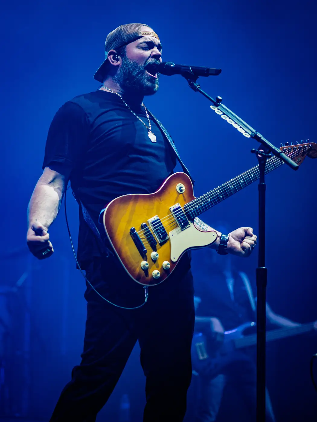 Lee Brice on electric guitar in deep blue light